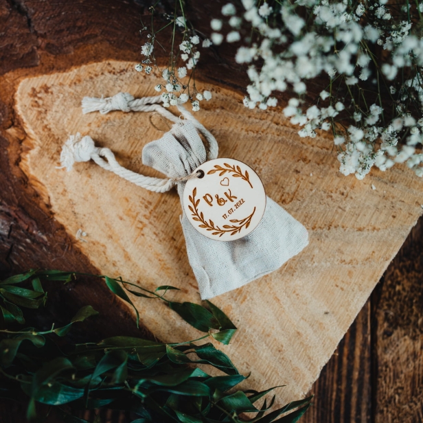 Upominek dla gości weselnych na ślub woreczek jutowy z pinem na sznurku jutowym